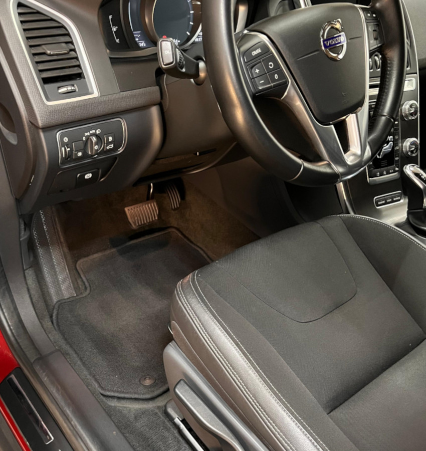 Interior coche turismo Volvo limpio. Tiene el salpicadero, asientos y alfombrillas relucientes.